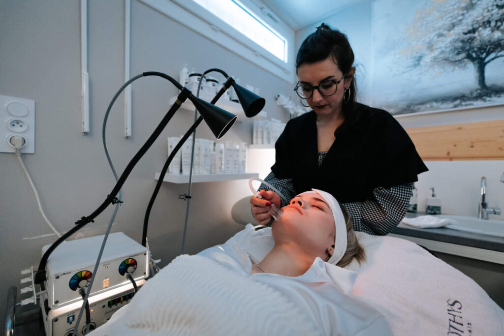 Photo d'une esthéticienne entrain de faire un soin visage
